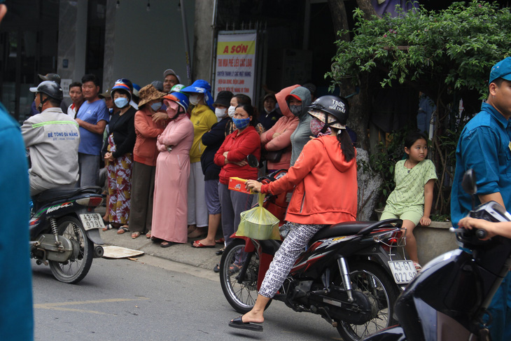 Người thân và hàng xóm trên đường Tôn Đản đợi chuyến xe từ Quảng Ninh trở về - Ảnh: TR.TRUNG