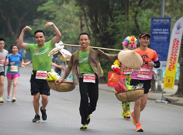 Chàng trai gánh dép chạy 21km ở Hà Nội - Ảnh 1.