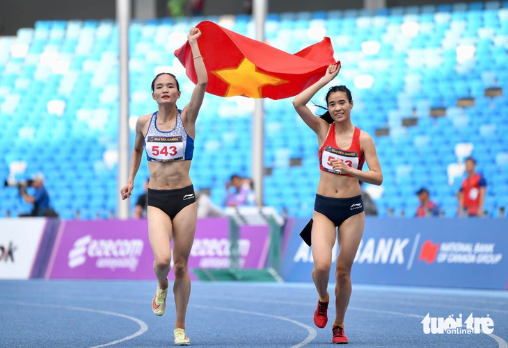Nguyễn Thị Thu Hà (trái) và Bùi Thị Ngân ăn mừng sau khi lần lượt giành HCV, HCB 800m nữ - Ảnh: NAM TRẦN