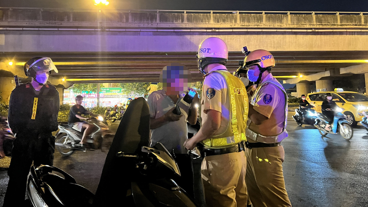 Cảnh sát giao thông Đội Hàng Xanh xử lý người vi phạm nồng độ cồn tối 19-3 - Ảnh: MINH HÒA