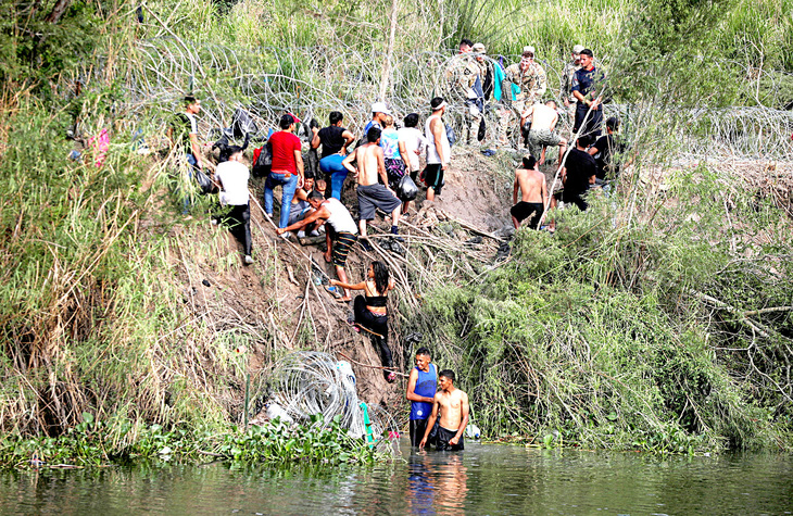Những người di cư bơi qua sông Rio Bravo để tự nộp mình cho lực lượng biên phòng Mỹ trước khi Điều khoản 42 kết thúc (ảnh chụp tại khu vực thuộc TP Matamoros, Mexico hôm 10-5) - Ảnh: Reuters