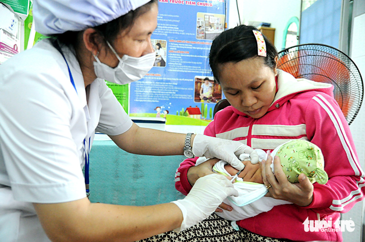 Nhân viên trạm y tế phường Trảng Dài (TP Biên Hòa, Đồng Nai) tiêm ngừa cho một trẻ trên địa bàn - Ảnh: A LỘC