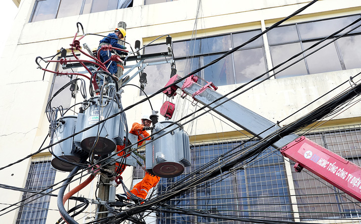 Nhân viên Công ty Điện lực Phú Thọ (TP.HCM) bảo trì lưới điện trung thể nhằm đảm bảo nguồn điện sinh hoạt cho người dân (ảnh chụp vào trưa 15-5) - Ảnh: HỮU HẠNH