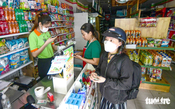 Một cửa hàng trên đường Nguyễn Văn Đậu, quận Bình Thạnh, TP.HCM phải tính tiền khách hàng bằng điện thoại do bị mất điện tạm thời lúc 16h45 ngày 19-5 - Ảnh: QUANG ĐỊNH