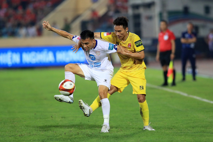Pha tranh bóng giữa cầu thủ Nam Định (áo trắng) và Hải Phòng trên sân Thiên Trường - Ảnh: MINH ĐỨC