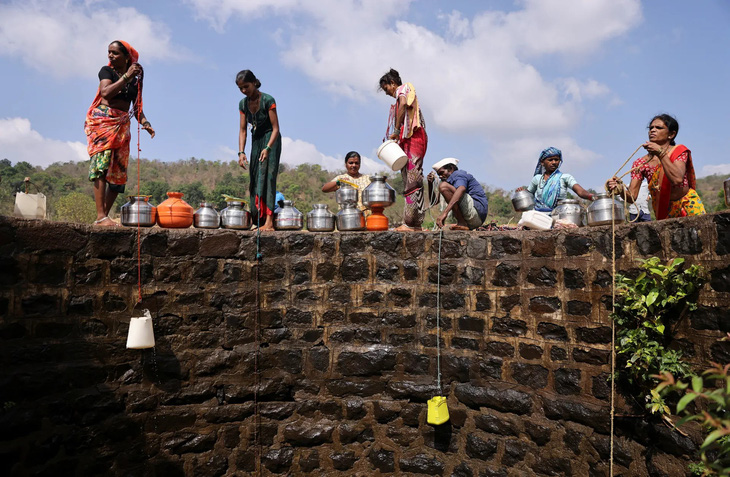 Những người phụ nữ đang thả mấy chiếc gầu nhựa để kéo nước lên từ cái giếng ở Telamwadi, Ấn Độ. Nơi này cách TP Mumbai khoảng 150km và cảnh này gần như tái diễn mỗi năm vào tháng 3 đến tháng 5 khi nhiệt độ có thể lên tới 40 độ C - Ảnh: REUTERS