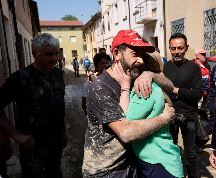 Thủ tướng Ý Giorgia Meloni (người áo xanh) xúc động khi gặp người dân vùng bị lũ lụt lịch sử Emilia-Romagna - Ảnh: REUTERS