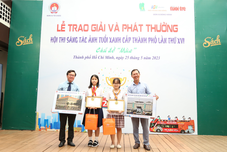 Ông Nguyễn Bảo Quốc - Phó giám đốc Sở Giáo dục Đào tạo TP. HCM (bìa trái) - và nhà báo Nguyễn Trường Uy - Phó Tổng Thư ký Toà soạn báo Tuổi Trẻ - trao thưởng cho hai học sinh đạt giải nhất hội thi sáng tác ảnh Tuổi Xanh - Ảnh: PHƯƠNG QUYÊN