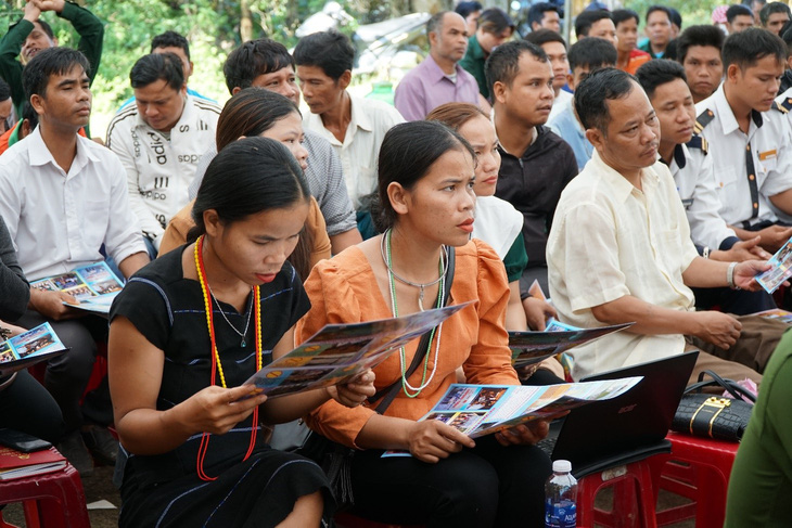 Người dân trong vùng dự án được nhận tờ rơi tuyên truyền từ Công ty CP thủy điện A Vương - Ảnh: Lê Lãm