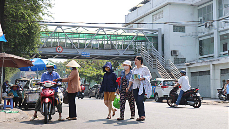 Người đi bộ vô tư đi cắt ngang đường mặc dù gần đó có cầu bộ hành Nguyễn Tri Phương (Q.5, TP.HCM) -  Ảnh: NGỌC PHƯỢNG