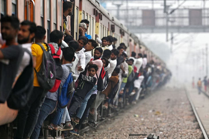 Người dân đu bám lên một con tàu ở gần nhà ga tại thị trấn Loni, bang Uttar Pradesh của Ấn Độ vào hôm 24-4 vừa qua. Liên Hiệp Quốc ước tính tới cuối tháng 6 năm nay, Ấn Độ sẽ vượt Trung Quốc, trở thành nước đông dân nhất thế giới - Ảnh: AFP