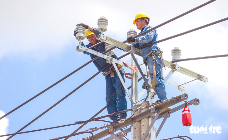 Tăng giá điện đồng thời ngành điện cũng tăng đầu tư hệ thống đường dây truyền tải nhằm phục vụ điện ổn định. Trong ảnh: thi công điện trên quốc lộ 50, huyện Bình Chánh, TP.HCM - Ảnh: QUANG ĐỊNH
