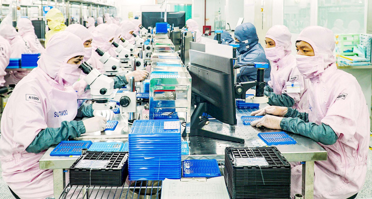 Công nhân Công ty Sungwoo Vina tại Khu công nghiệp Thuận Thành 3 (Bắc Ninh) đang sản xuất theo đơn hàng của Samsung trong phòng sạch - Ảnh: NGUYỄN HIỀN