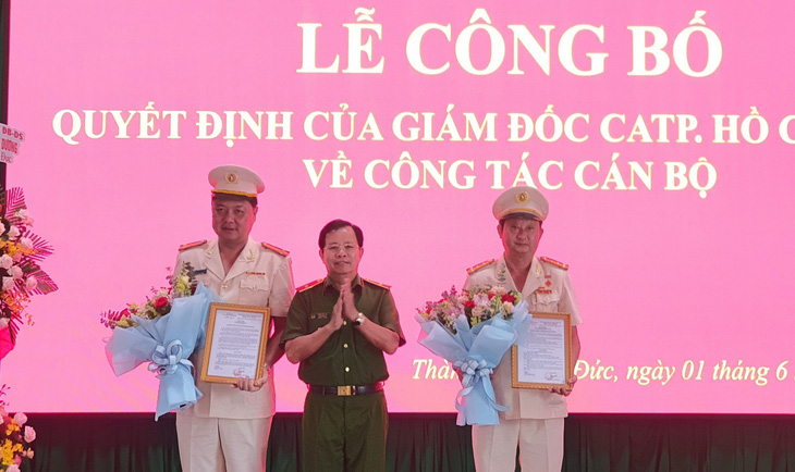 Thiếu tướng Trần Đức Tài trao quyết định cho đại tá Nguyễn Hoàng Thắng (bìa phải) và thượng tá Nguyễn Đình Dương (bìa trái) - Ảnh: MINH HÒA
