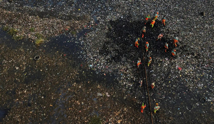 Một nhóm người đang cố gắng thu gom rác thải, trong đó hầu hết là rác nhựa và rác thải sinh hoạt ở một khu vực thuộc thủ đô Jakarta, Indonesia - Ảnh: REUTERS