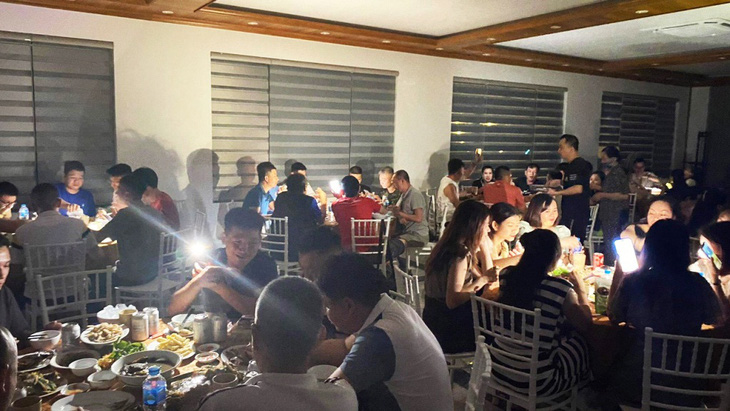 Do nhà hàng (xã đảo Minh Châu, huyện Vân Đồn) bị cắt điện, du khách phải bật đèn điện thoại để... ăn tối - Ảnh: HOÀNG QUỲNH