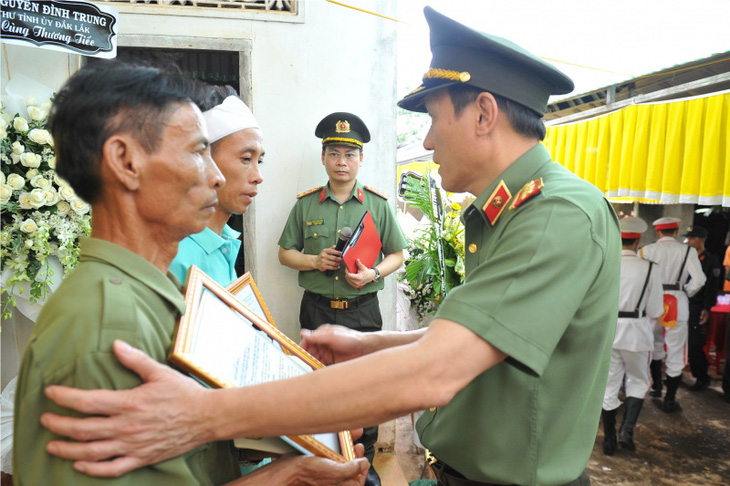 Thứ trưởng Lương Tam Quang trao Quyết định của Bộ trưởng Bộ Công an truy thăng cấp bậc hàm trước niên hạn và Quỹ “nghĩa tình đồng đội Công an nhân dân” cho gia đình thân nhân các Công an xã - Ảnh: CAND