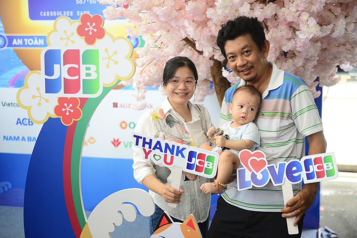 Gia đình anh Nguyễn Thanh Quốc Hưng chụp hình check-in tại gian hàng JCB - Ảnh: QUANG ĐỊNH