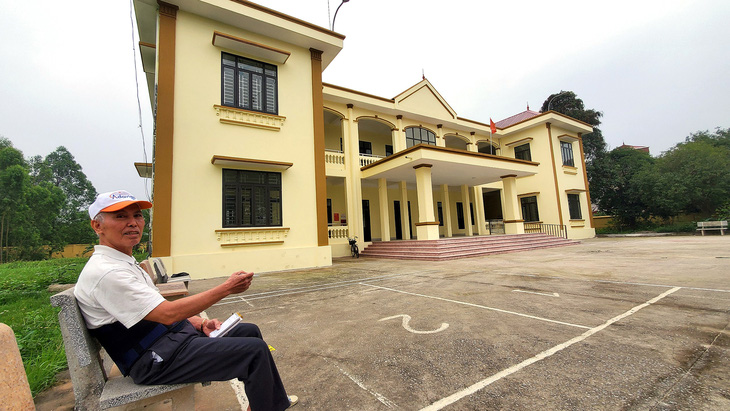 Ông Nguyễn Anh Hào - trưởng ban quỹ hưu nông dân - bên tòa nhà văn hóa mới xây dựng từ vay quỹ hưu