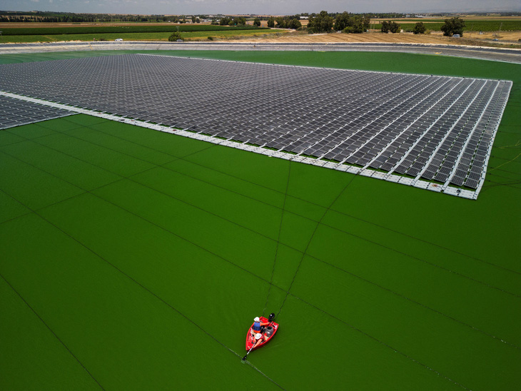 Các công nhân của hãng Nofar Energy đang lắp đặt những tấm pin điện mặt trời trên một hồ chứa nước ở bên ngoài vùng Or HaNer thuộc miền nam Israel vào ngày 19-6-2023 - Ảnh: REUTERS