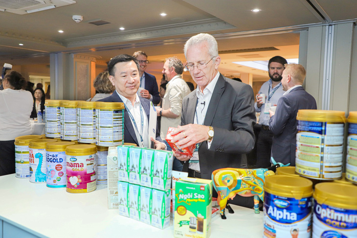 Ông Richard Hall, chủ tịch Hội nghị sữa toàn cầu (bên phải), hào hứng tìm hiểu về các sản phẩm sữa của Vinamilk mang đến Hội nghị năm nay.