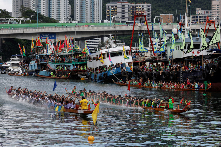 Những chiếc thuyền rồng đang đua chèo về đích trong dịp Tết Đoan ngọ (5-5 âm lịch), còn có tên khác là Lễ hội thuyền rồng, ở cảng cá Aberdeen của Hong Kong, Trung Quốc ngày 22-6. (Reuters/Tyrone Siu) 