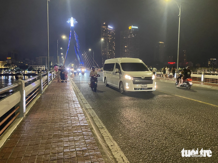Lúc 21h48, sau khi kết thúc bắn pháo hoa, xe cộ được cho đi lại qua cầu Sông Hàn. Dường như không có dấu hiệu cho thấy trước đó 30 phút nơi đây có hàng ngàn người ngồi xem pháo hoa - Ảnh: TRƯỜNG TRUNG