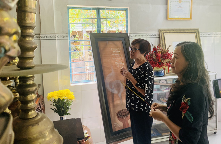 Bà Thế Thanh và nghệ sĩ Hải Phượng (bìa phải) thắp hương tưởng nhớ giáo sư Trần Văn Khê - Ảnh: HOÀI PHƯƠNG