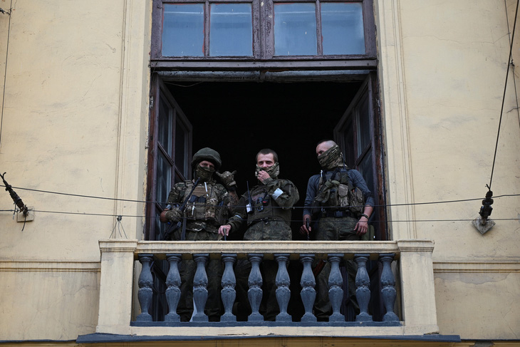 Các chiến binh Wagner đứng trên ban công khi được triển khai tại trụ sở Quân khu miền nam Nga ở thành phố Rostov-on-Don, Nga ngày 24-6 - Ảnh: REUTERS