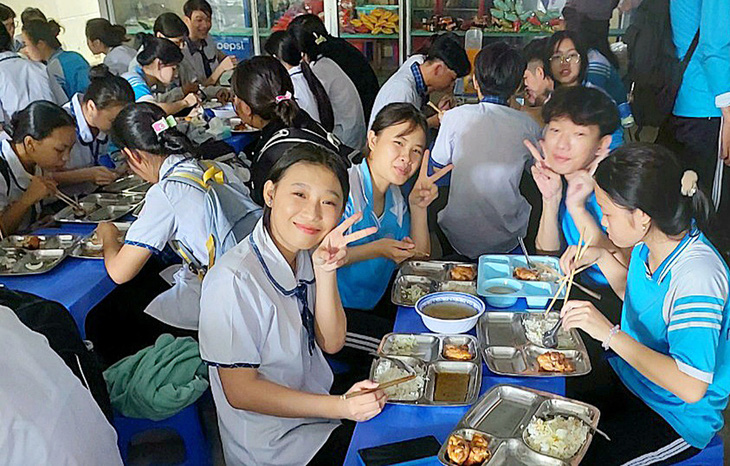 Nụ cười tươi của cô cậu học trò Trường THCS & THPT Trần Ngọc Hoằng khi được thưởng thức phần cơm trưa thấm đượm nghĩa tình - Ảnh: NGỌC DIỄM