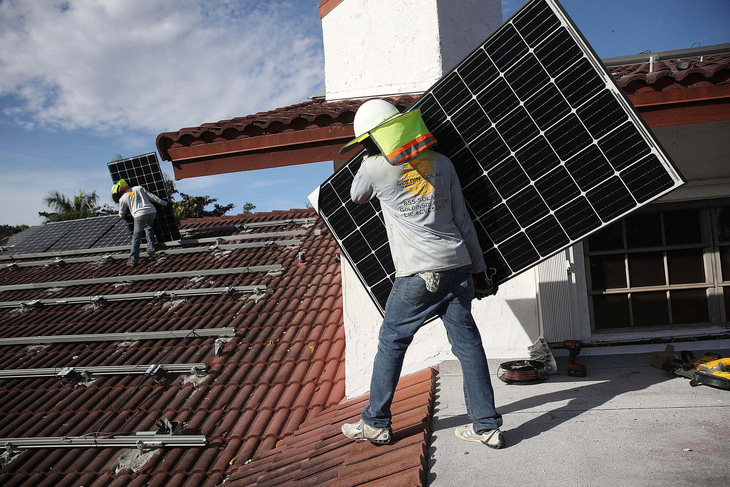 Một công nhân đang lắp đặt các tấm pin mặt trời ở bang Florida, Mỹ. Ảnh: Getty Images