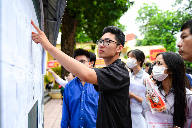Thí sinh tham dự kỳ thi tốt nghiệp THPT năm 2023 xem danh sách phòng thi được niêm yết tại một hội đồng thi ở Hà Nội - Ảnh: NAM TRẦN
