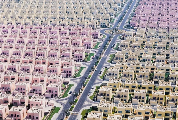 Trong hình là khu biệt thự liền kề được xây dựng với thiết kế các ngôi nhà giống hệt nhau tại vùng ngoại ô thành phố Dubai, UAE. Các ngôi nhà được sơn theo hai tông màu sắp xếp theo hệ thống đường phố hình chữ nhật. (Guardian/ Florian Kriechbaumer) 
