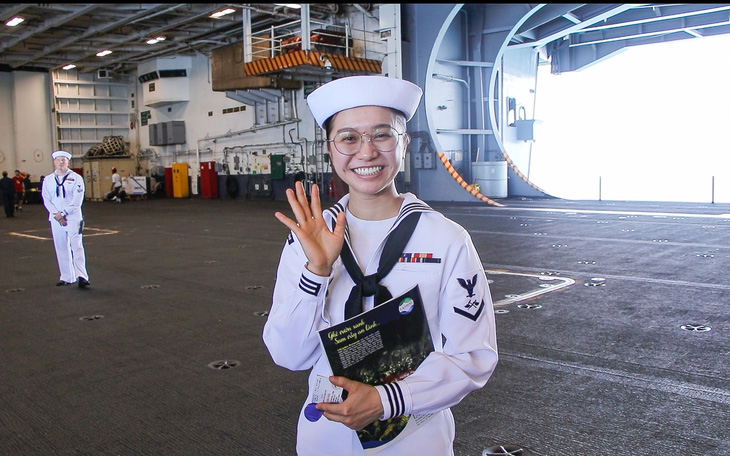 Đoàn Nhật Huyền Trân thu hút nhiều sự chú ý của các vị khách tham quan tàu USS Ronald Reagan vì lúc nào cũng tươi cười và nói tiếng Việt - Ảnh: DUY LINH