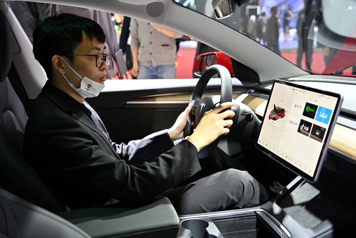 Người tham dự Triển lãm ô tô quốc tế Thượng Hải ngồi thử trên một chiếc xe điện Tesla - Ảnh: AFP