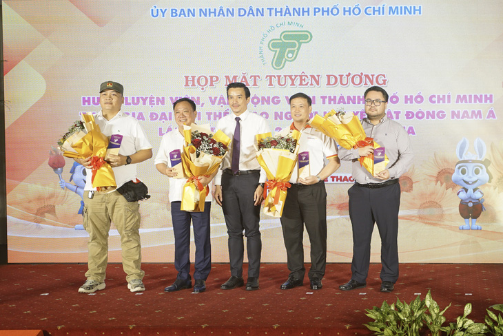 Ông Đào Văn Kính - phó chủ tịch HĐQT DatVietVAC Group Holdings (thứ hai từ trái sang) - nhận hoa và quà lưu niệm từ ông Nguyễn Nam Nhân - phó giám đốc Sở VH-TT TP.HCM