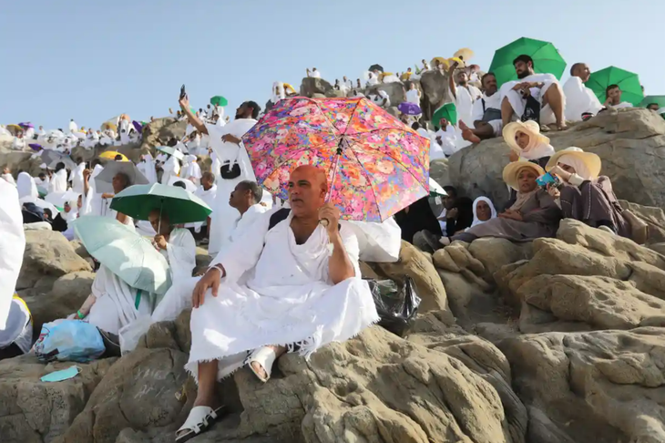 Người hành hương che dù để tránh nắng trên đỉnh núi Arafat - Ảnh: AFP