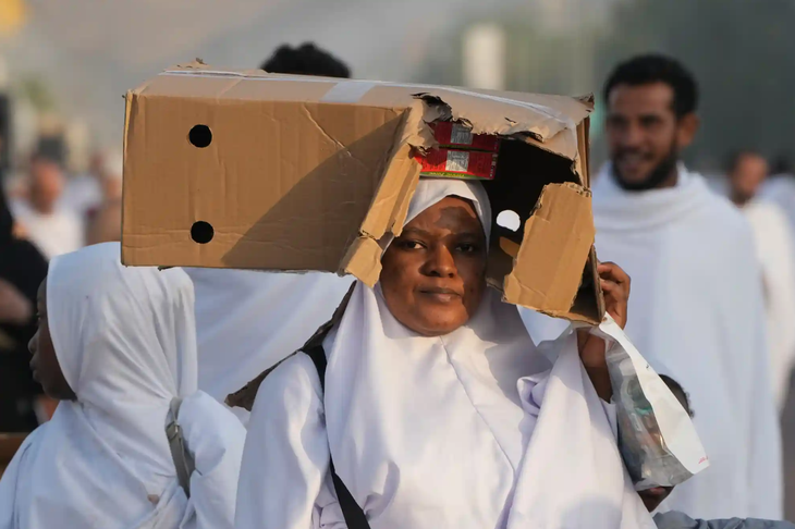 Một phụ nữ cố che tránh để khỏi nắng - Ảnh: AFP