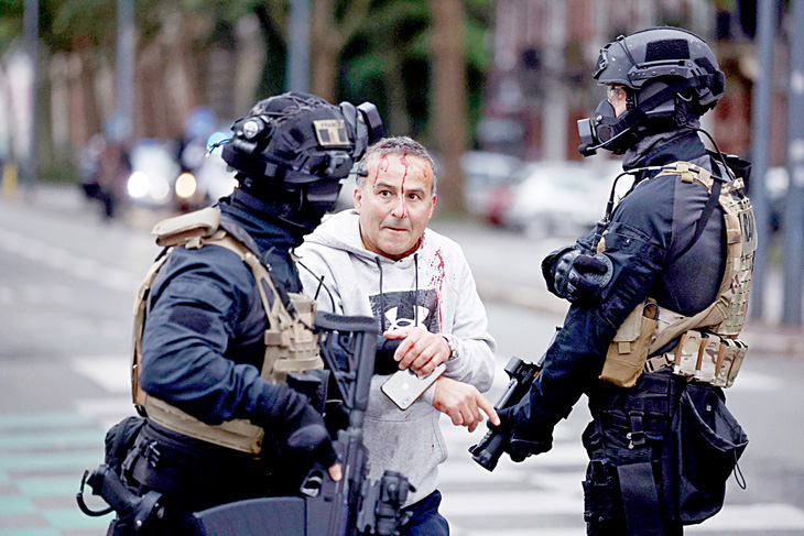 Một người biểu tình đổ máu khi bị đội đặc nhiệm chống khủng bố RAID của Pháp bắt giữ ở thành phố Lille vào ngày 29-6 - Ảnh: AFP