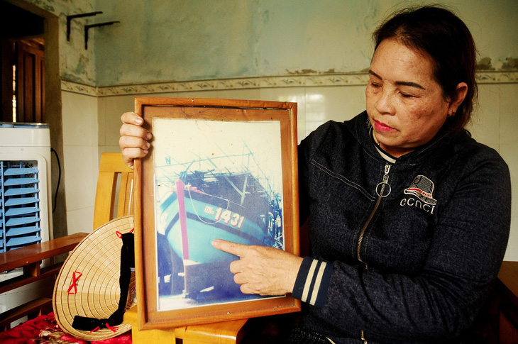 Bà Lâm với tấm ảnh tàu cá định mệnh mà chồng con bà cùng các ngư dân đã gặp nạn