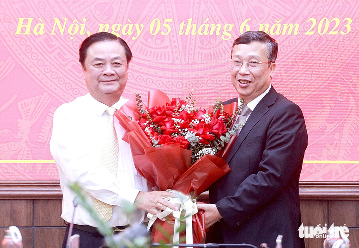 Bộ trưởng Bộ Nông nghiệp và Phát triển nông thôn Lê Minh Hoan tặng hoa chúc mừng ông Hoàng Trung - Ảnh: C.TUỆ