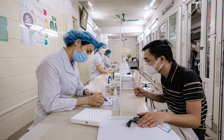 Các y bác sĩ tư vấn, lấy mẫu xét nghiệm tại Bệnh viện Bạch Mai - Ảnh: NAM TRẦN