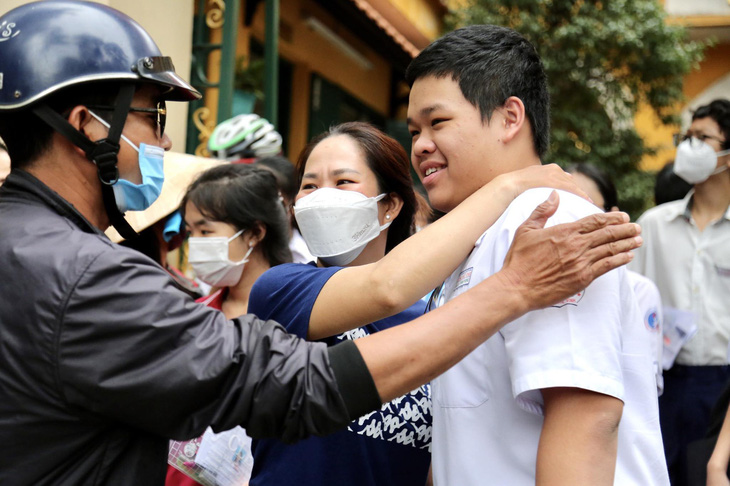 Cô giáo ôm chúc mừng học sinh hoàn thành môn thi toán trước cổng Trường THPT Trưng Vương (quận 1) - Ảnh: PHƯƠNG QUYÊN