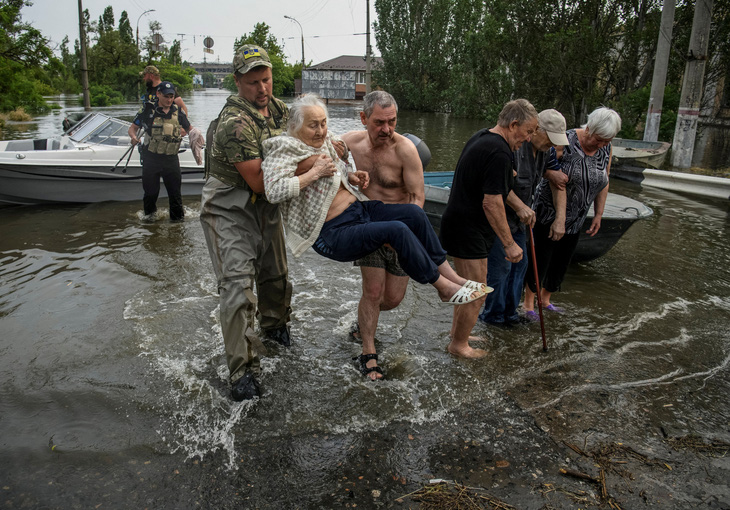 Lực lượng cứu hộ sơ tán cư dân địa phương khỏi khu vực bị ngập lụt sau khi đập Nova Kakhovka bị vỡ ngày 7-6 - Ảnh: REUTERS