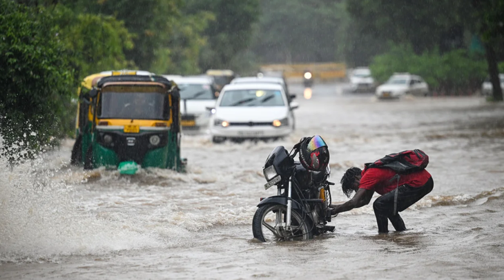 Xe cộ di chuyển trên đường ngập nước sau mưa lớn tại thủ đô New Delhi, Ấn Độ ngày 9-7 - Ảnh: HINDUSTAN TIMES