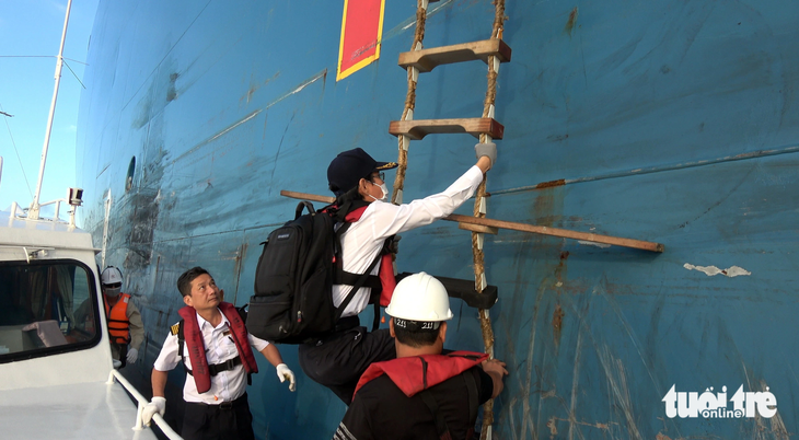 Hoa tiêu Phạm Trung Tín và Lê Ngọc Dương đang lên tàu Maran Gas Achilles chở LNG để dẫn vào cảng - Ảnh: ĐÔNG HÀ