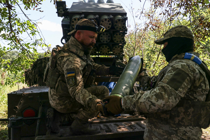 Quân nhân Ukraine nạp đạn vào hệ thống rocket phóng loạt cỡ nhỏ RAK-SA-12 bắn về phía quân đội Nga gần Bakhmut ngày 10-7 - Ảnh: REUTERS