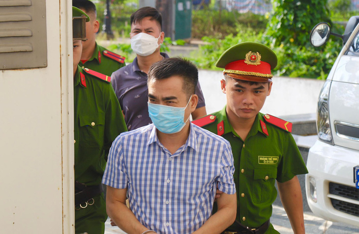 Bị cáo Lê Hồng Sơn - tổng giám đốc Công ty Bầu Trời Xanh - được dẫn giải đến phiên tòa "chuyến bay giải cứu" - Ảnh: DANH TRỌNG