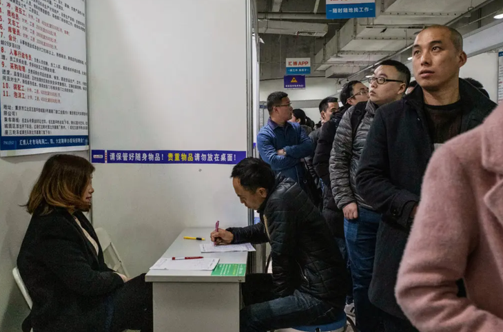 Một người đàn ông đang điền đơn xin việc ở thành phố Trùng Khánh, Trung Quốc - Ảnh: The New York Times