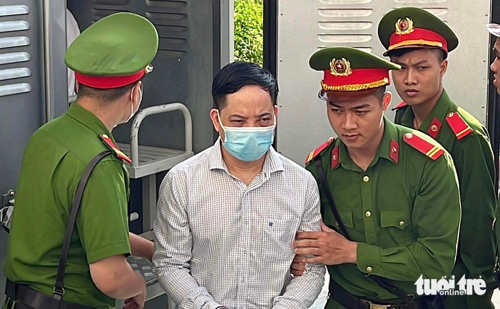Bị cáo Phạm Trung Kiên - cựu thư ký thứ trưởng Bộ Y tế - được dẫn giải đến phiên tòa xét xử vụ chuyến bay giải cứu - Ảnh: DANH TRỌNG